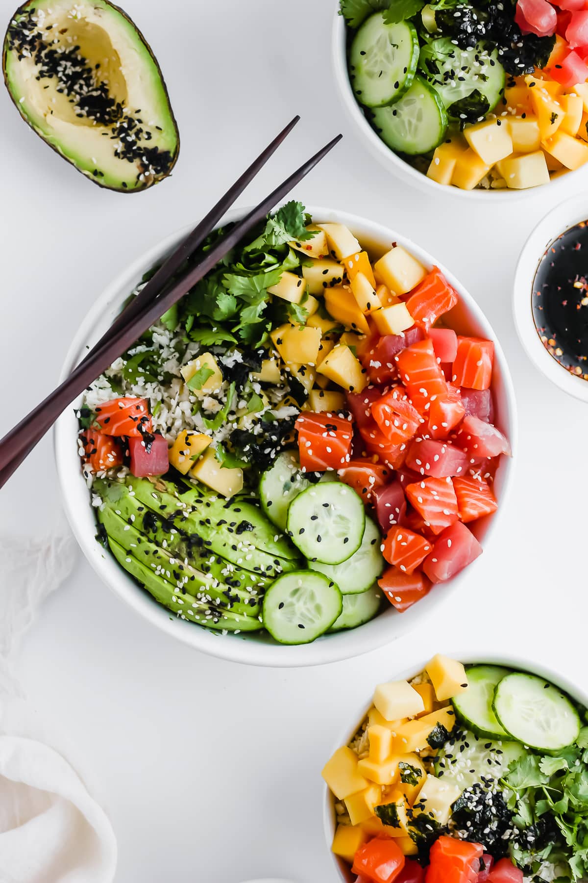 A shot of 3 Whole30 Poke bowls with chopsticks.