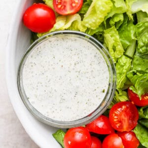 Bowl of lettuce with cherry tomatoes and dairy free ranch dressing.