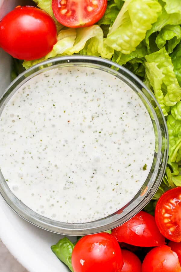 Bowl of lettuce with cherry tomatoes and dairy free ranch dressing.