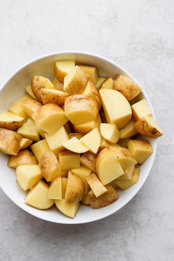 Chunks of potatoes in a large white bowl.