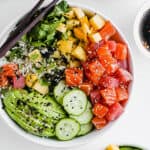 A big Whole30 Poke Bowl with salmon, mango, cucumbers and avocado.