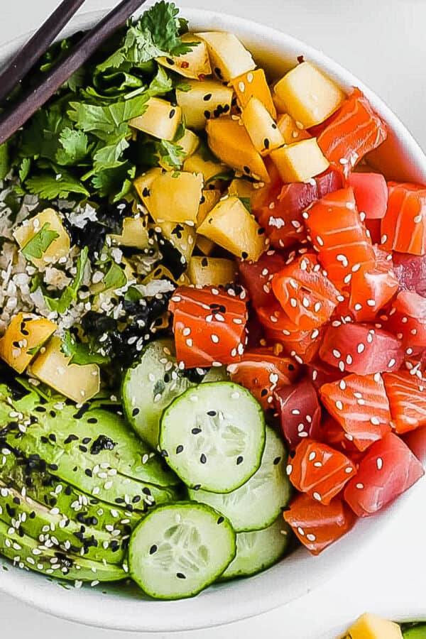 A big Whole30 Poke Bowl with salmon, mango, cucumbers and avocado.