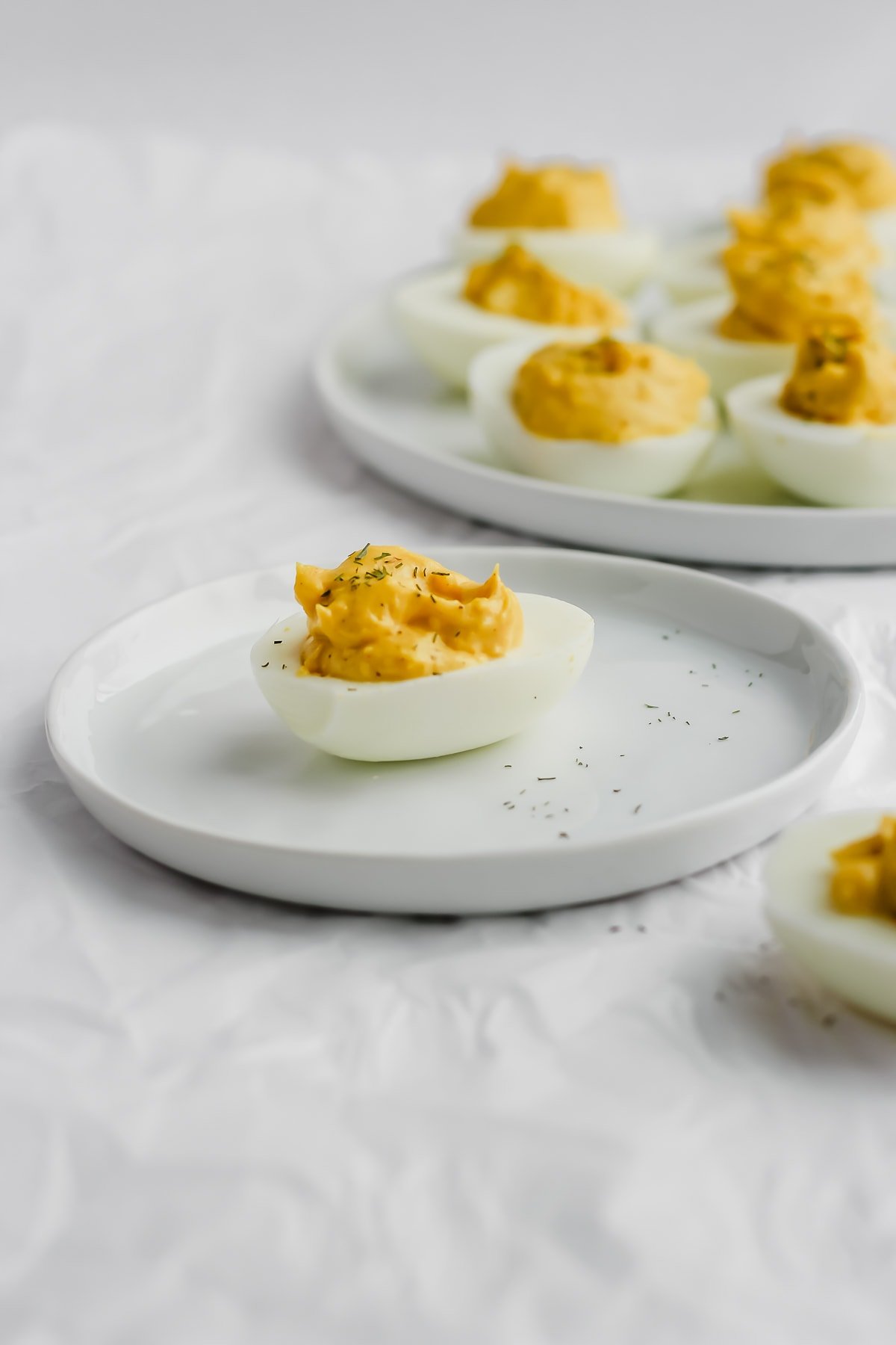 A whole30 deviled egg on a white plate.