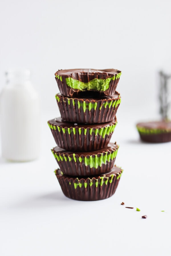 Five paleo matcha coconut butter cups stacked on top of each other.
