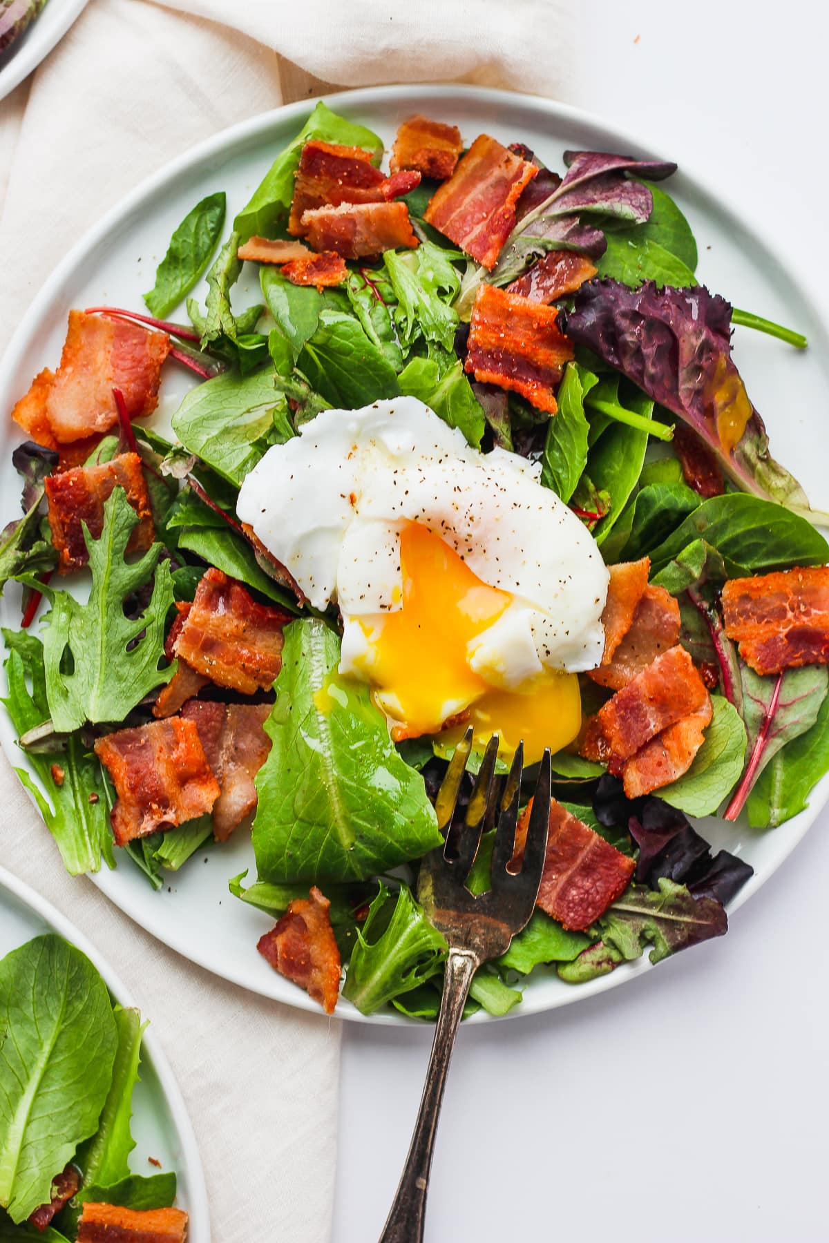 A fully assembled breakfast salad with a fork.