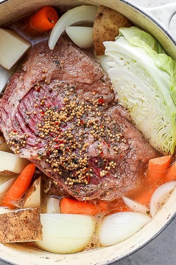 A Dutch Oven filled with cooked corned beef and cabbage.