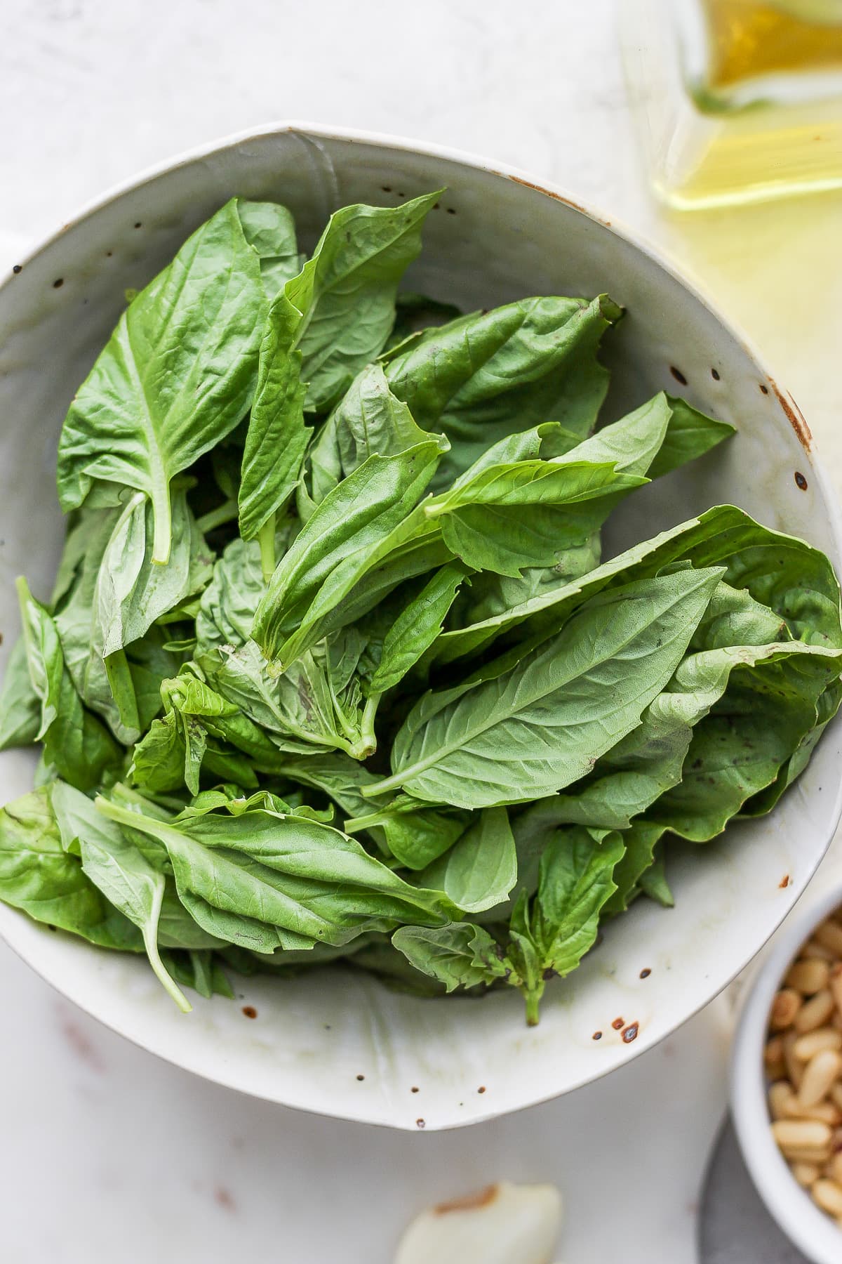 A bowl of fresh basil leaves. 