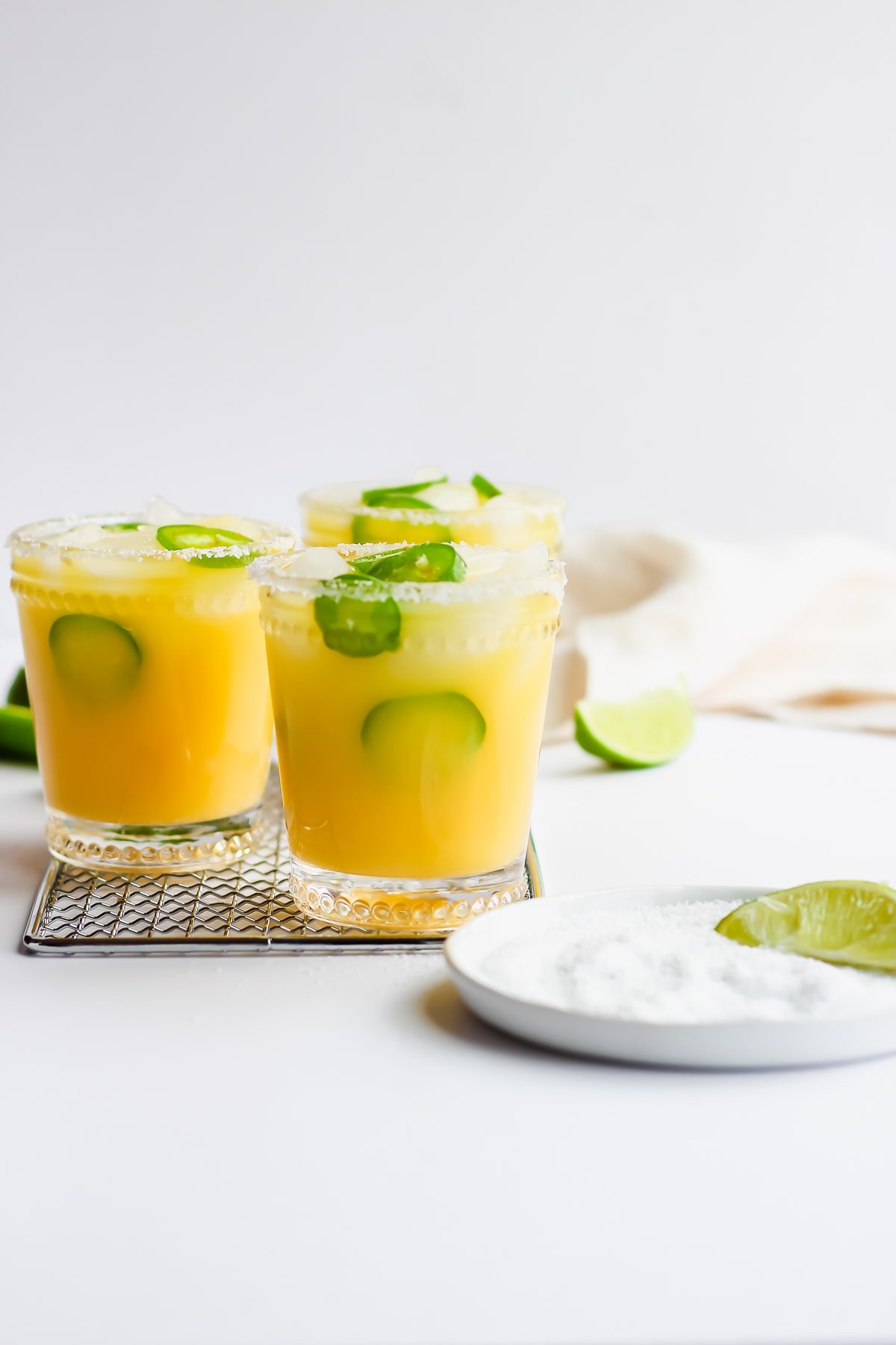 Straight on shot of some margarita mocktails with jalapeno. 
