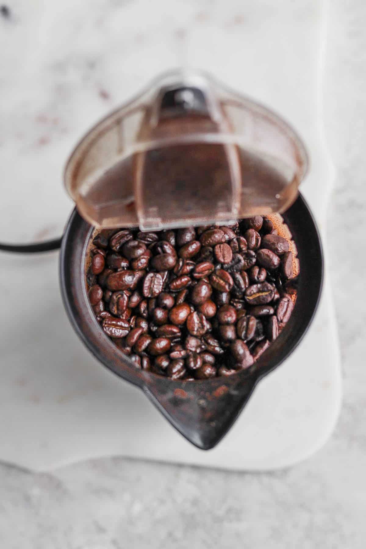 Coffee beans inside a coffee grinder.