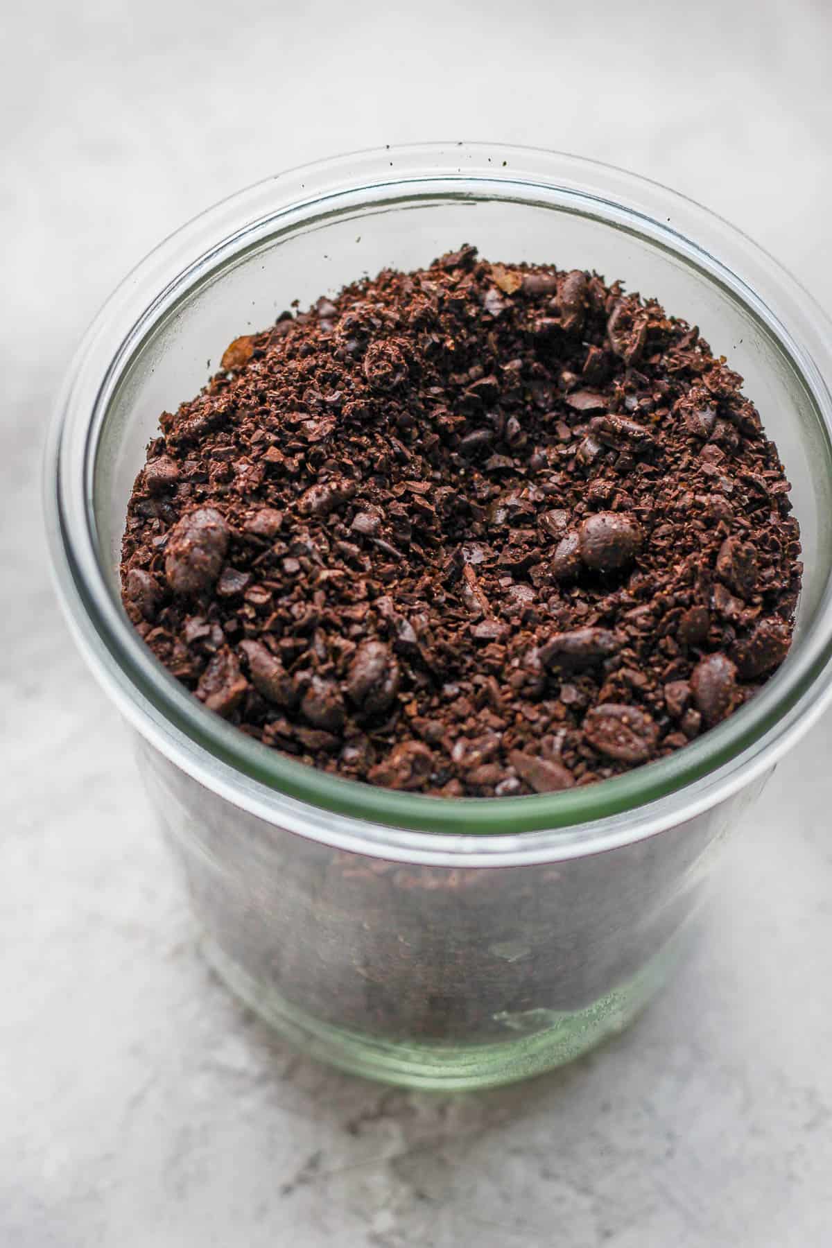 Roughly ground coffee beans in a glass container. 