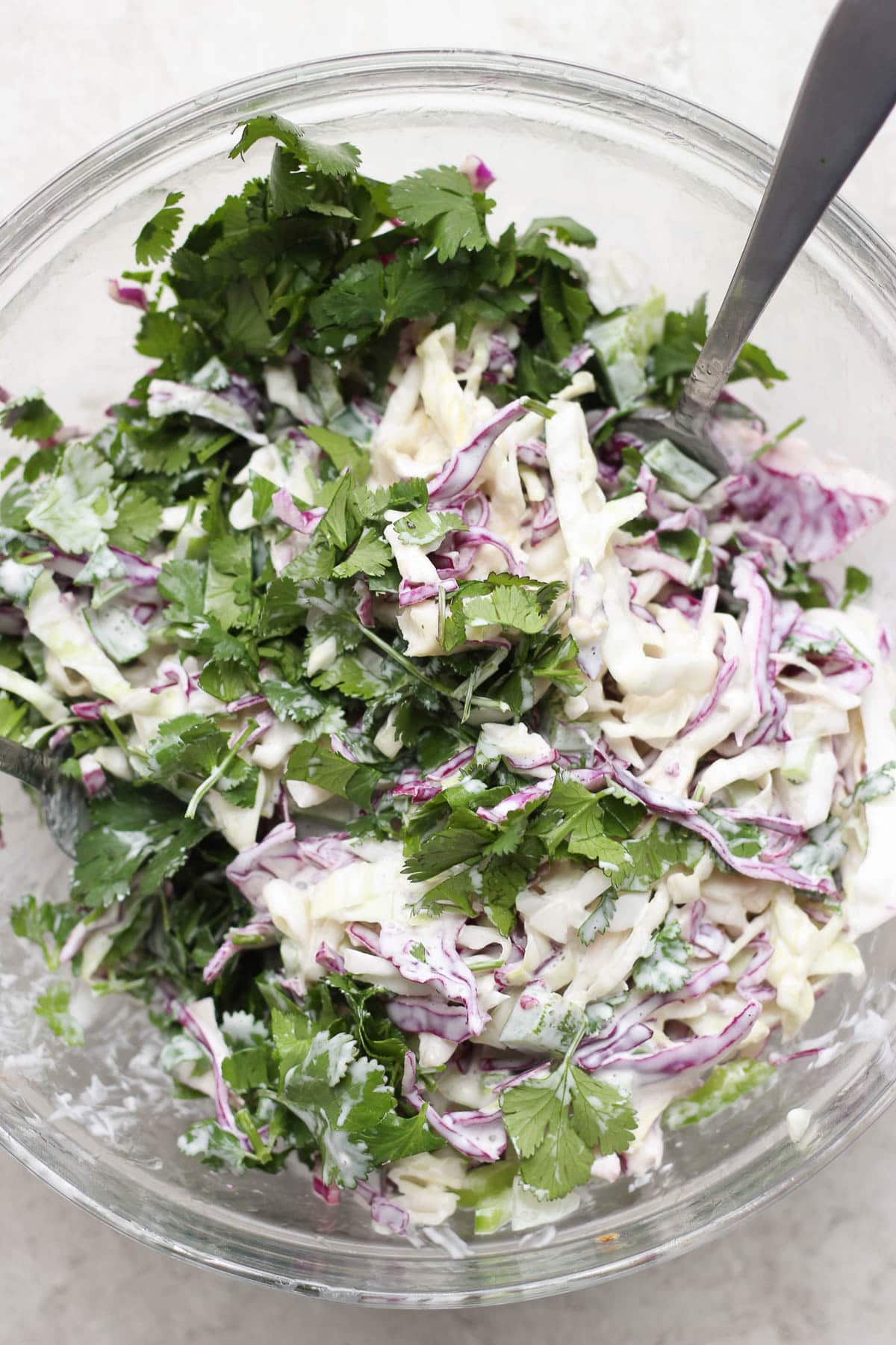 A glass bowl of spicy purple cabbage coleslaw.