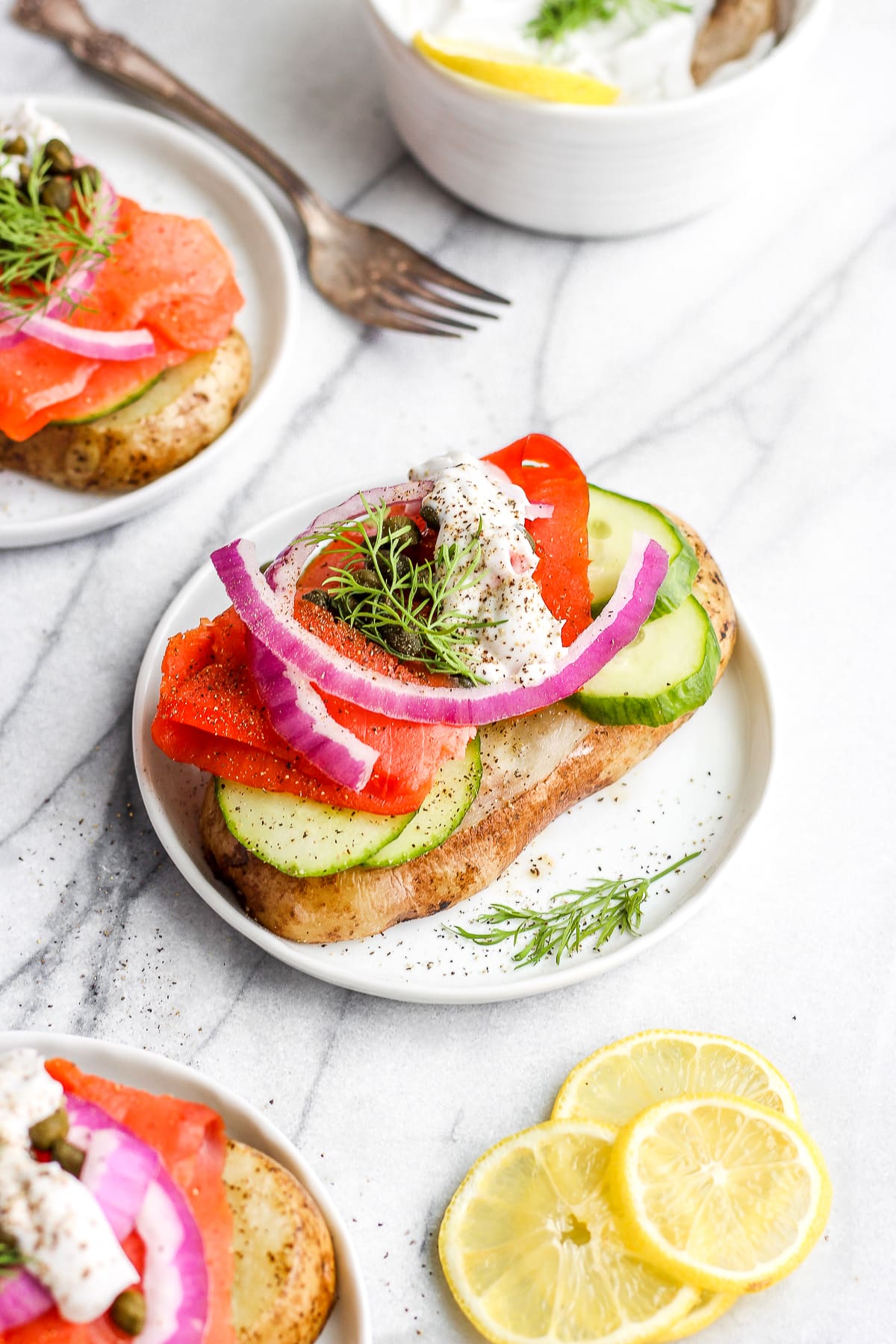 A slice of smoked salmon toast on a white plate.