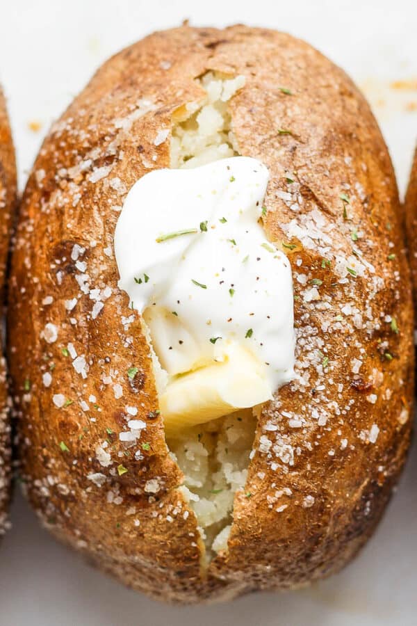 A baked potato with ghee and dairy free sour cream.