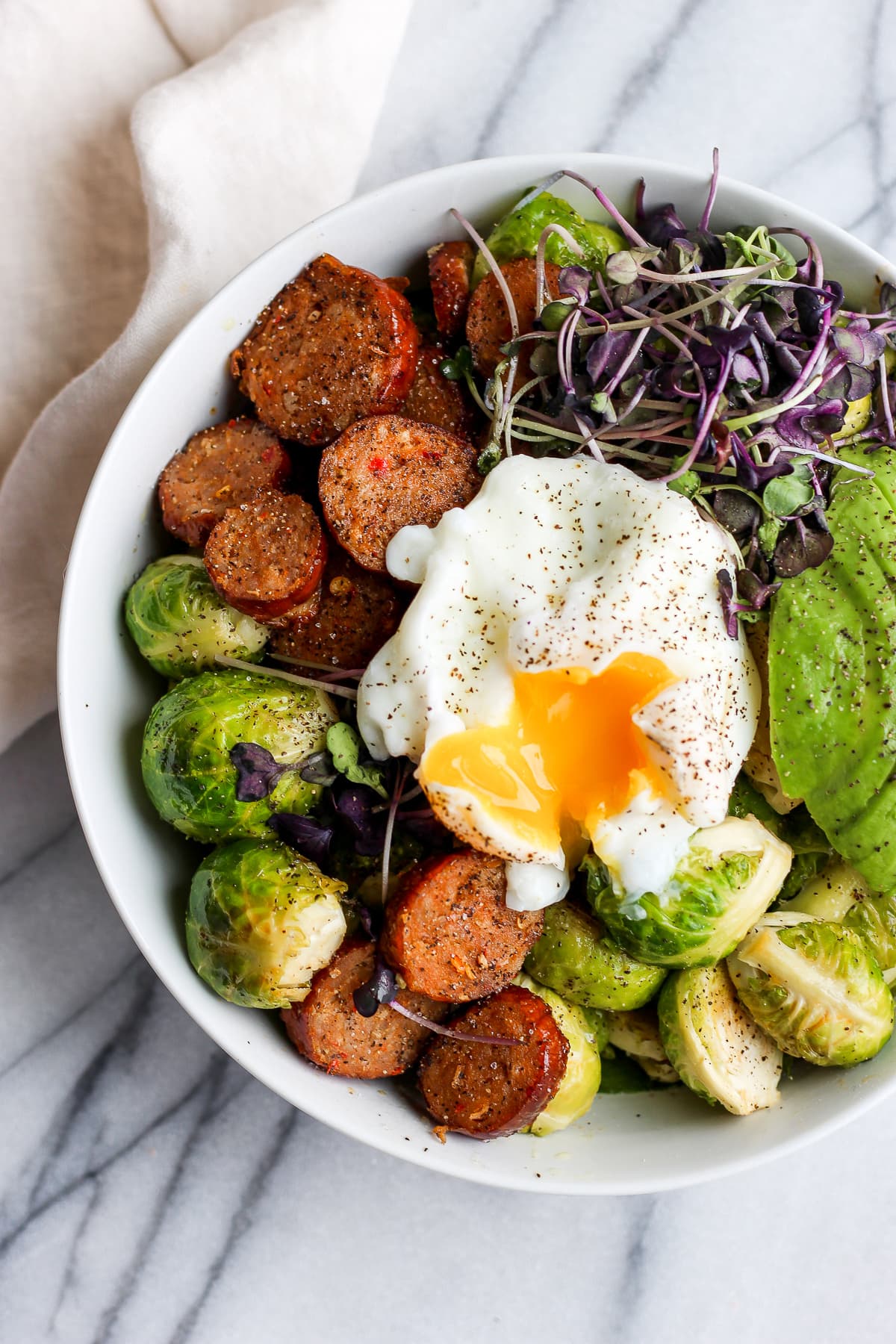 Chorizo sheet pan dinner bowl after cutting into the poached egg.