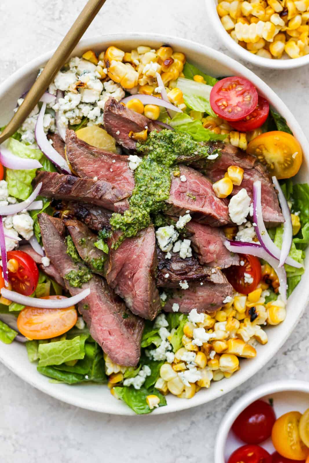 Bowl of flank steak salad with chimichurri, corn and blue cheese.