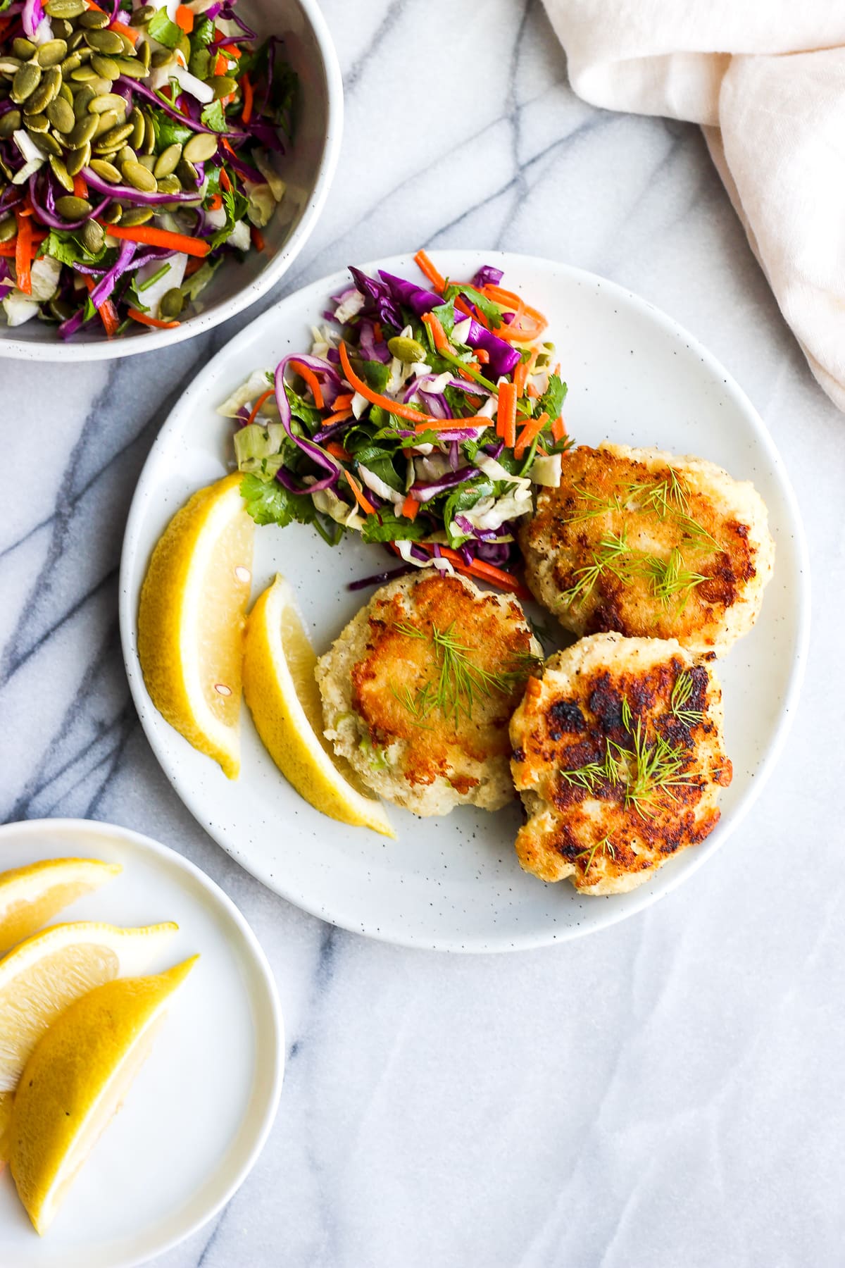 Cod Cakes on a plate with a side salad.