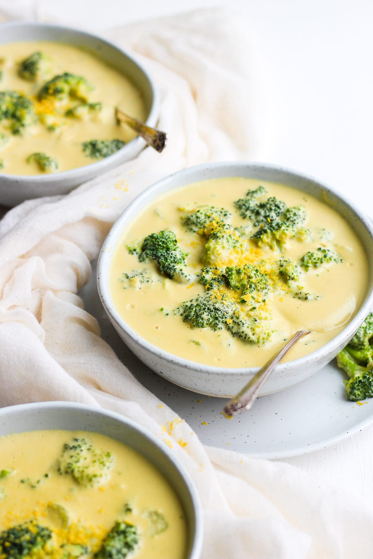 Individual bowls of vegan broccoli cheese soup.