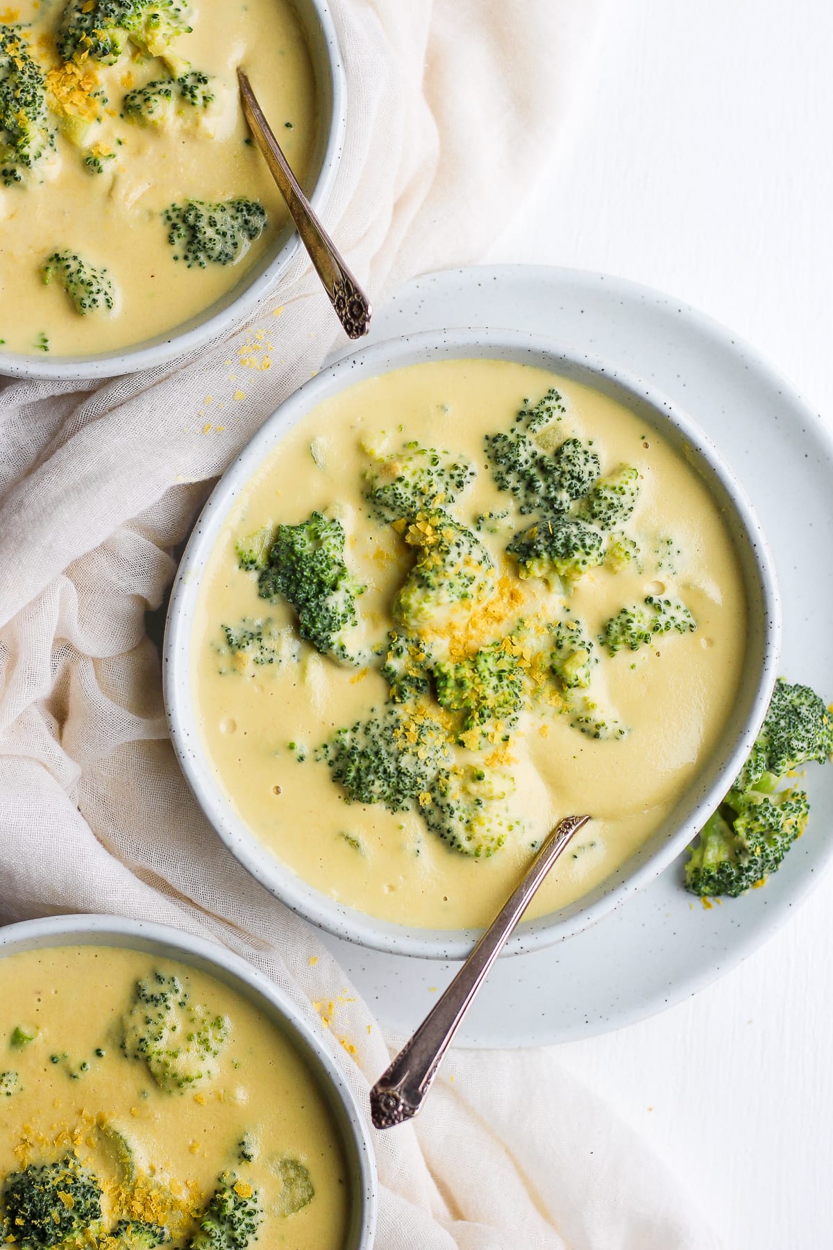 A bowl of vegan broccoli cheese soup with a sprinkling of nutritional yeast on top.