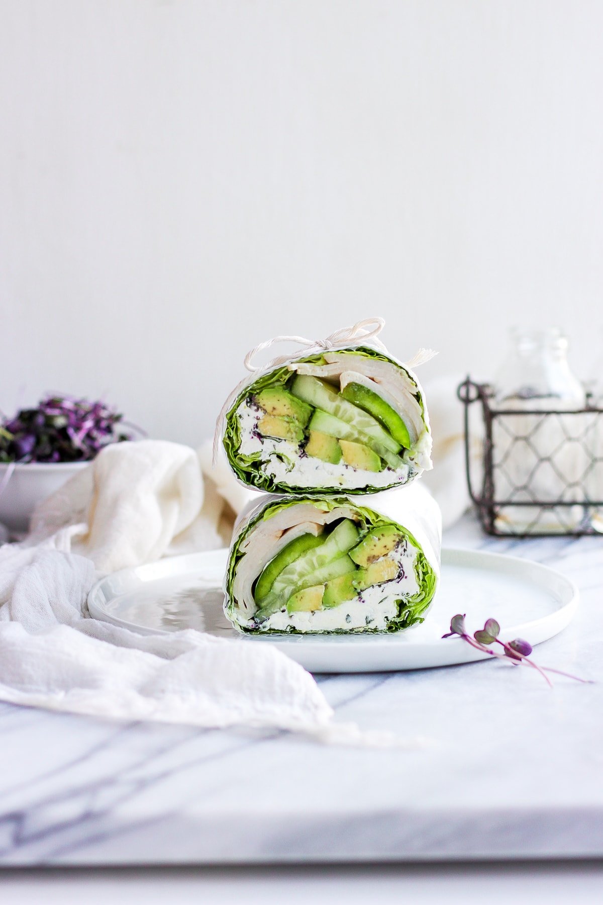 A turkey lettuce wrap on a white plate.