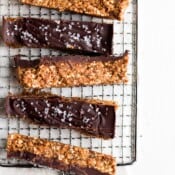 A wire rack full of six raw cashew chocolate breakfast bars.