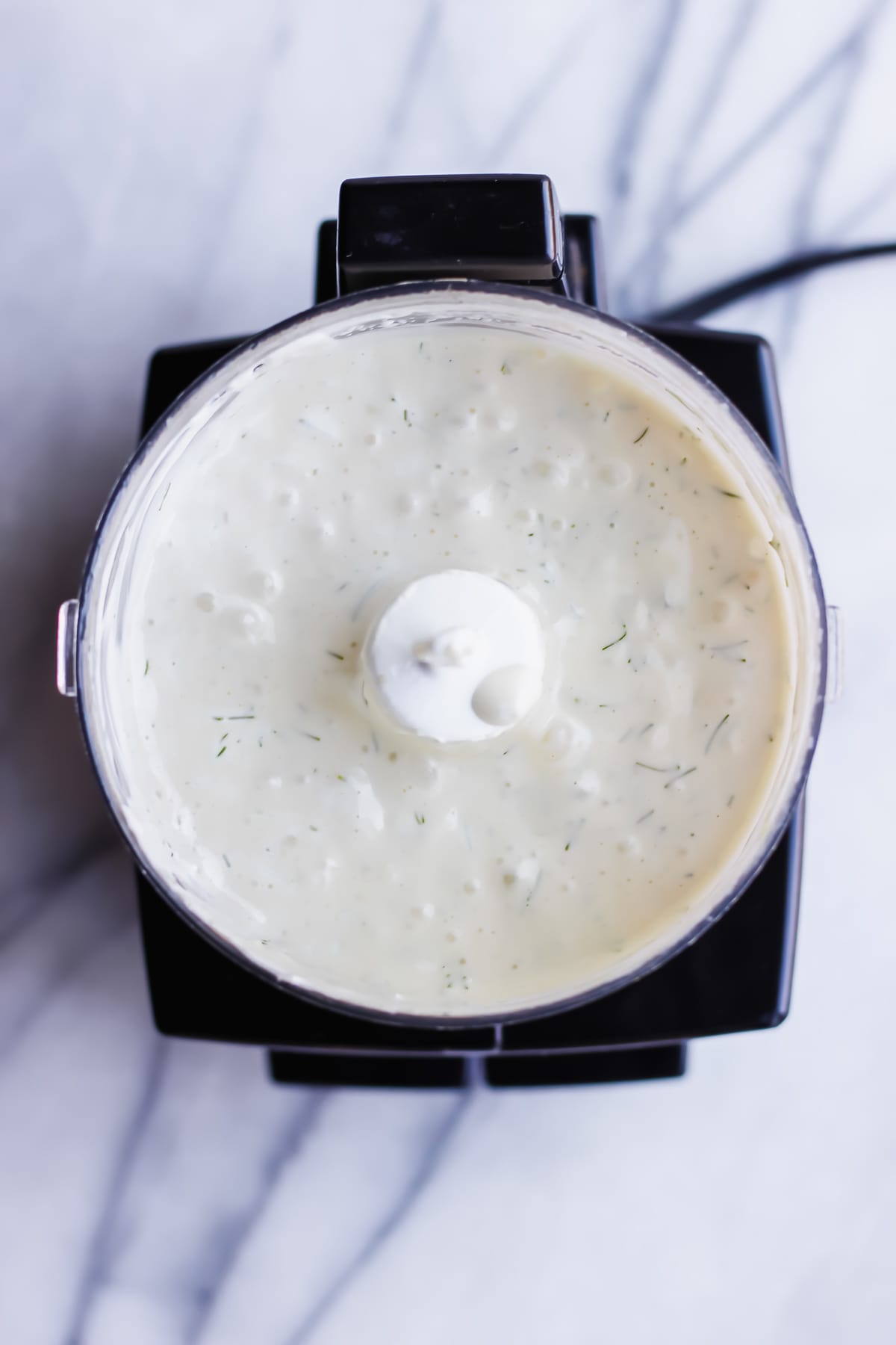 Blended whole30 tartar sauce ingredients in a food processor. 