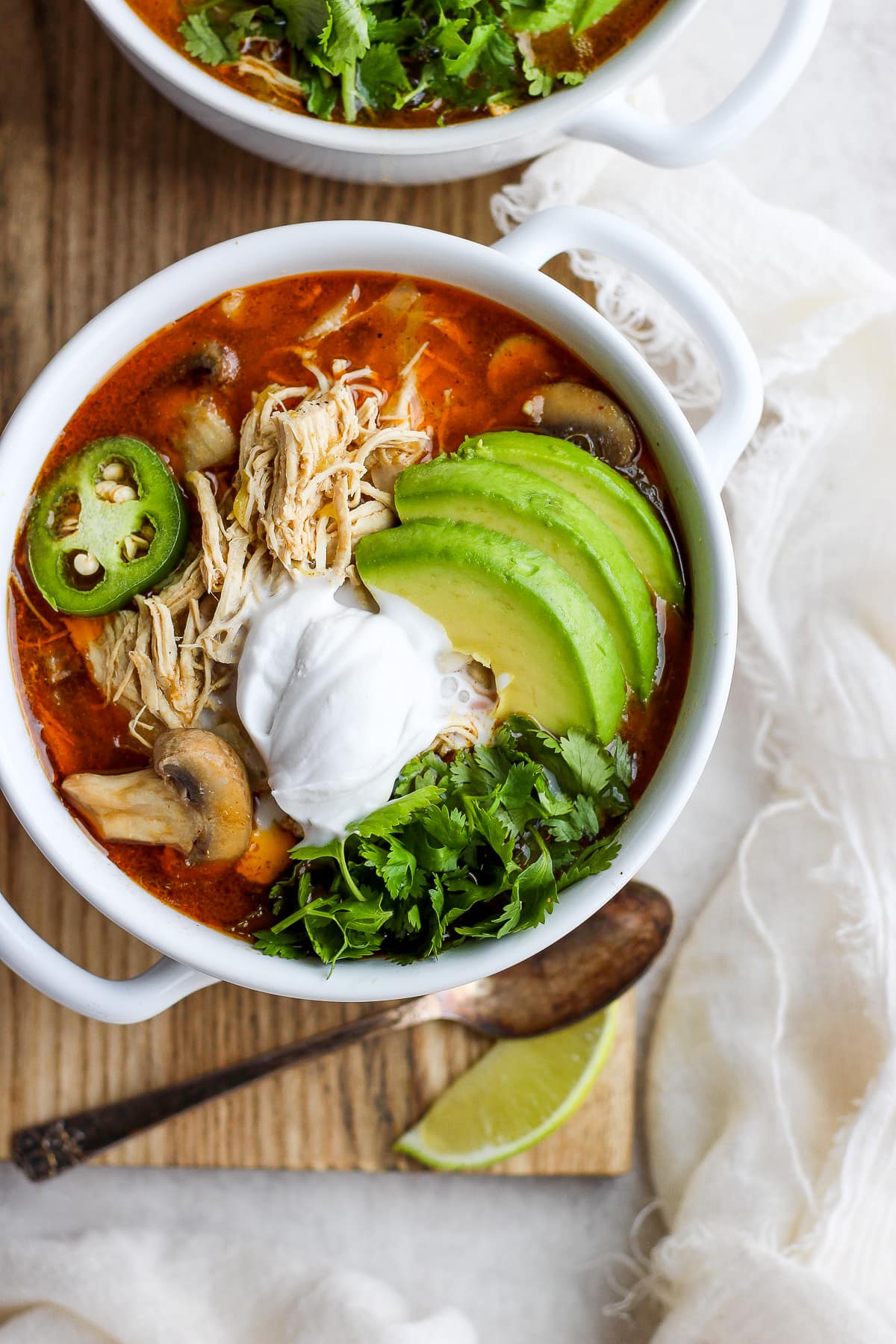 Creamy Slow cooker White Chicken Chili in a bowl garnished with avocado, fresh cilantro and jalapeño. 