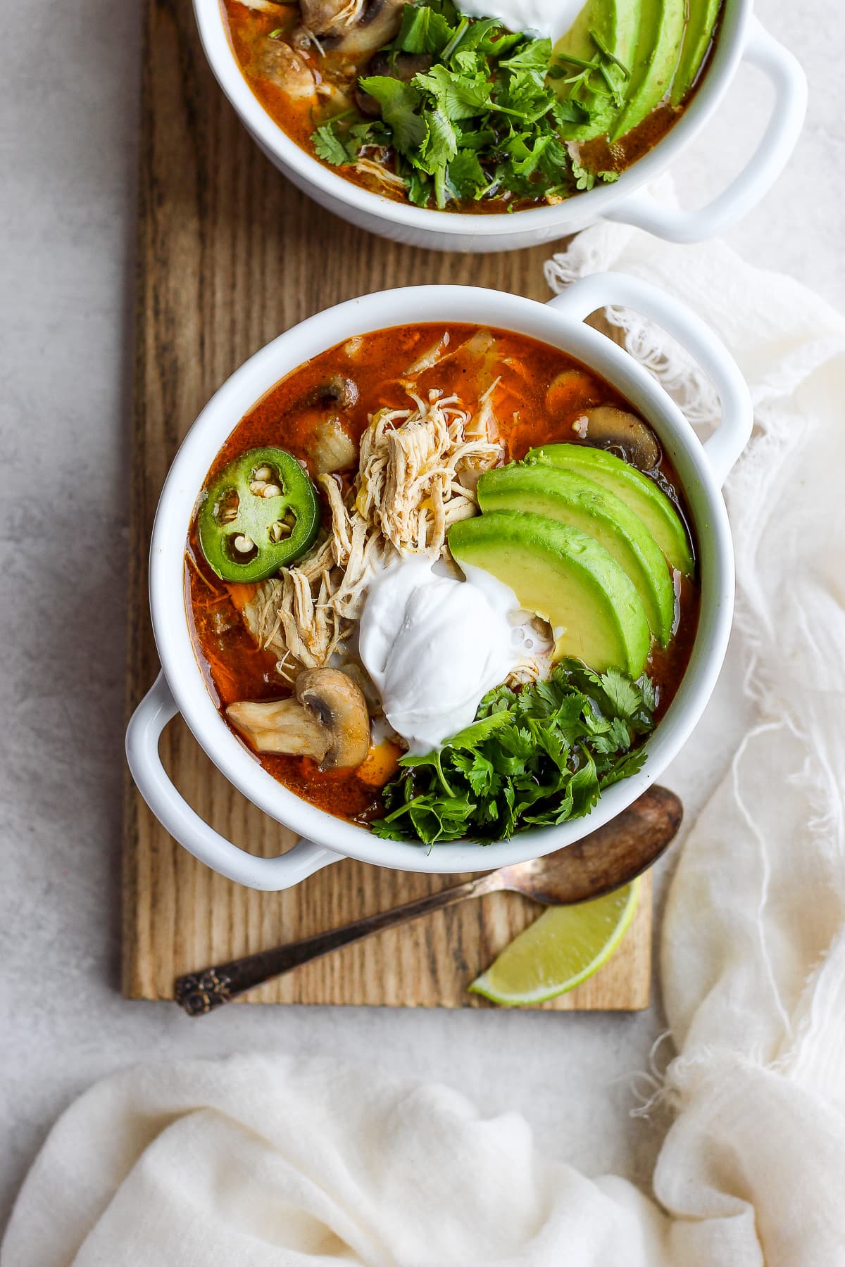 Creamy Slow cooker White Chicken Chili in a bowl garnished with avocado, fresh cilantro and jalapeño. 