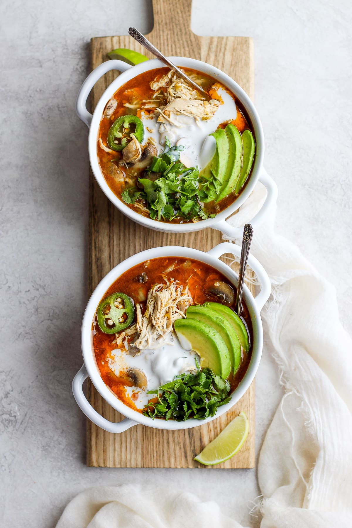 Creamy Slow cooker White Chicken Chili in a bowl garnished with avocado, fresh cilantro and jalapeño. 