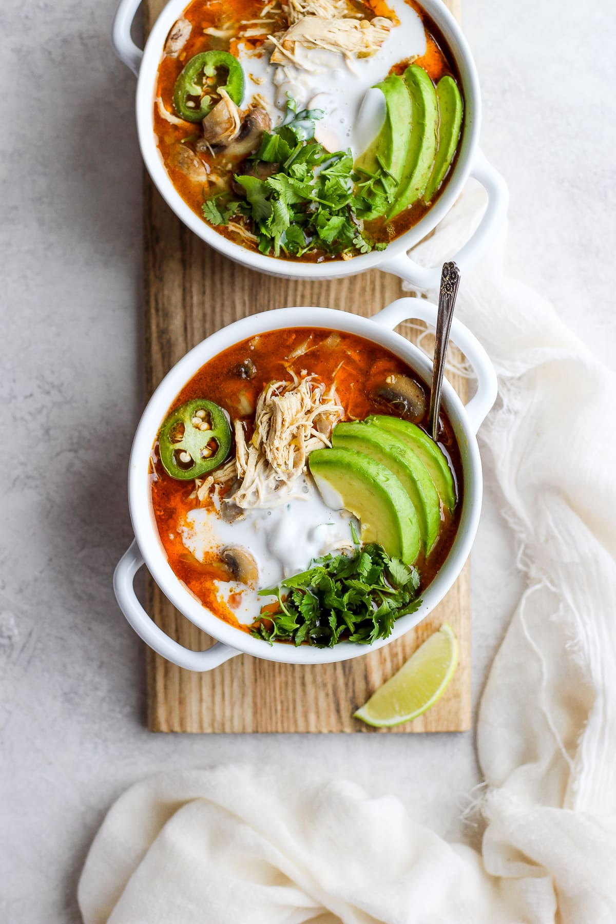 Creamy Slow cooker White Chicken Chili in a bowl garnished with avocado, fresh cilantro and jalapeño. 