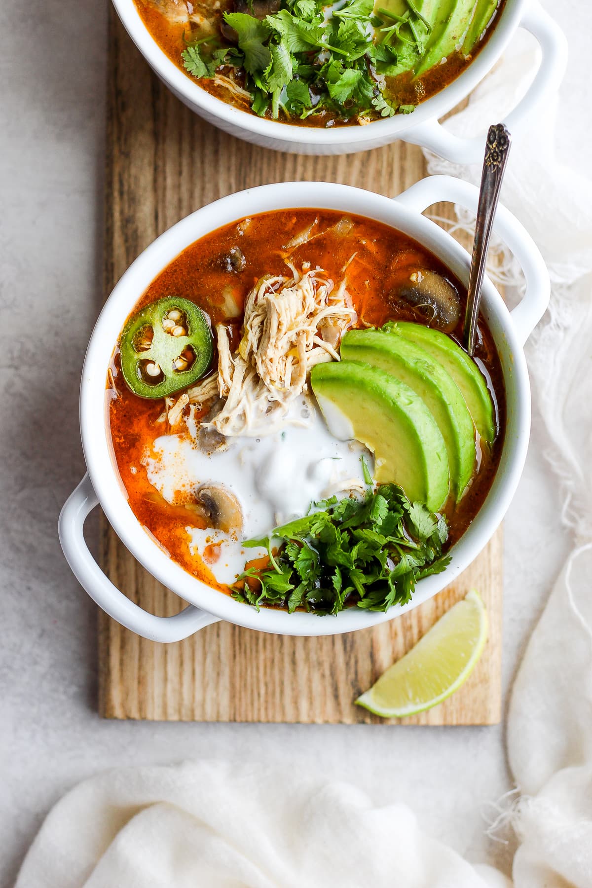 Creamy Slow cooker White Chicken Chili in a bowl garnished with avocado, fresh cilantro and jalapeño. 