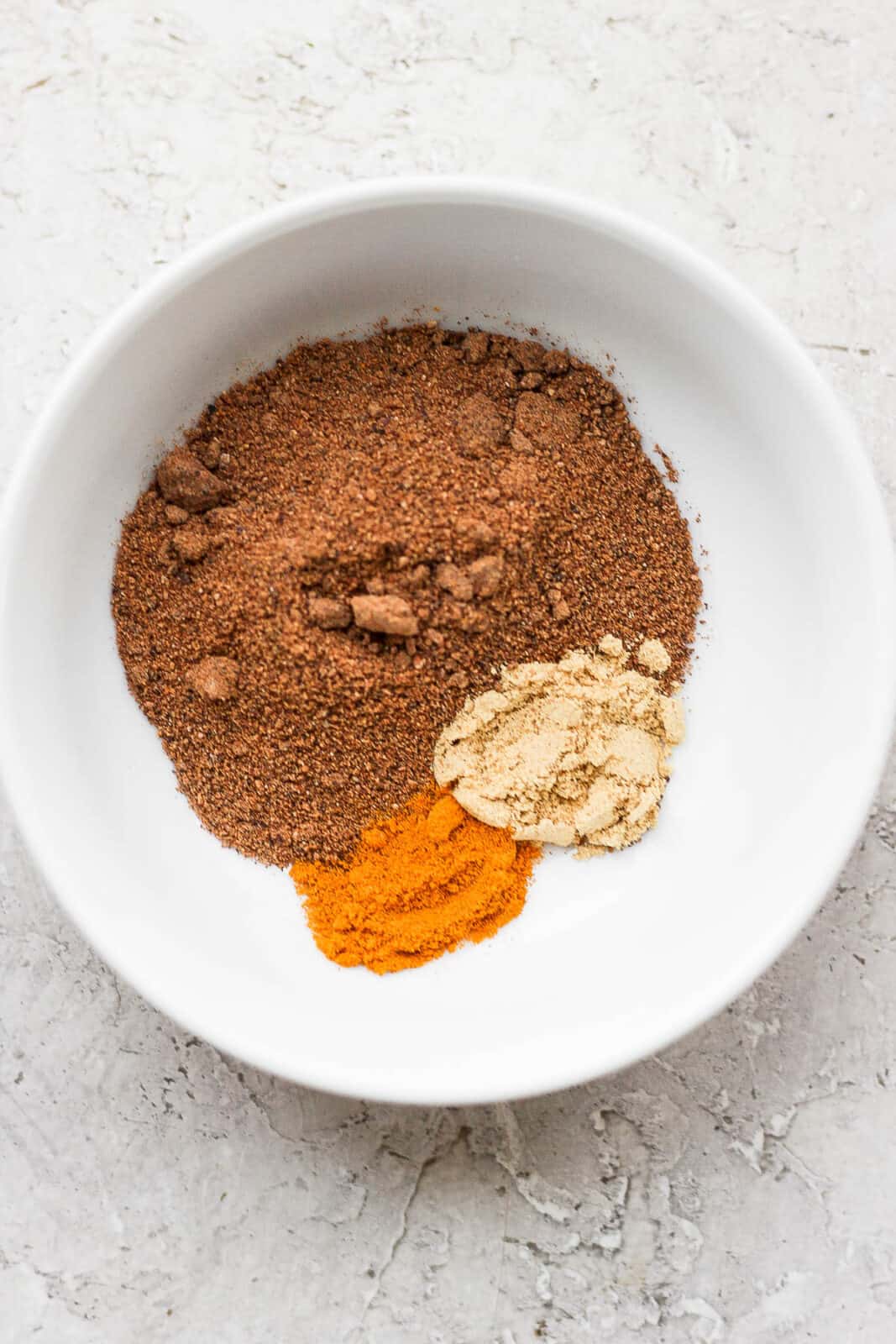 Nutmeg, ginger and turmeric in a small bowl.