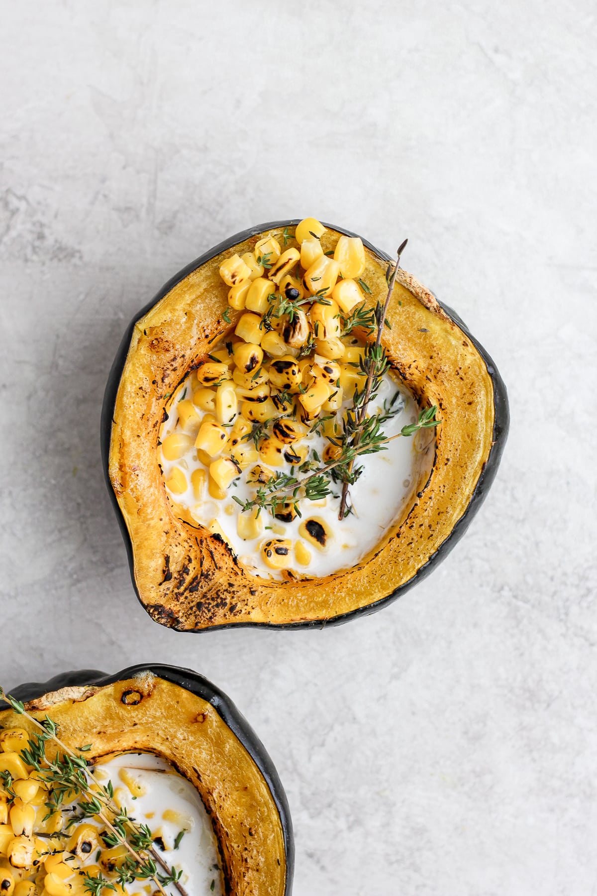 Close-up shot of one creamy corn acorn squash on the counter.