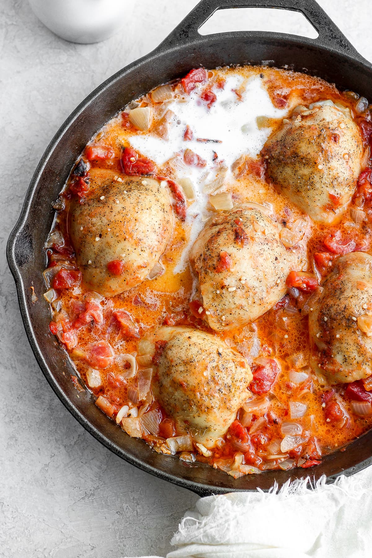 Chicken and tomato sauce in the skillet.