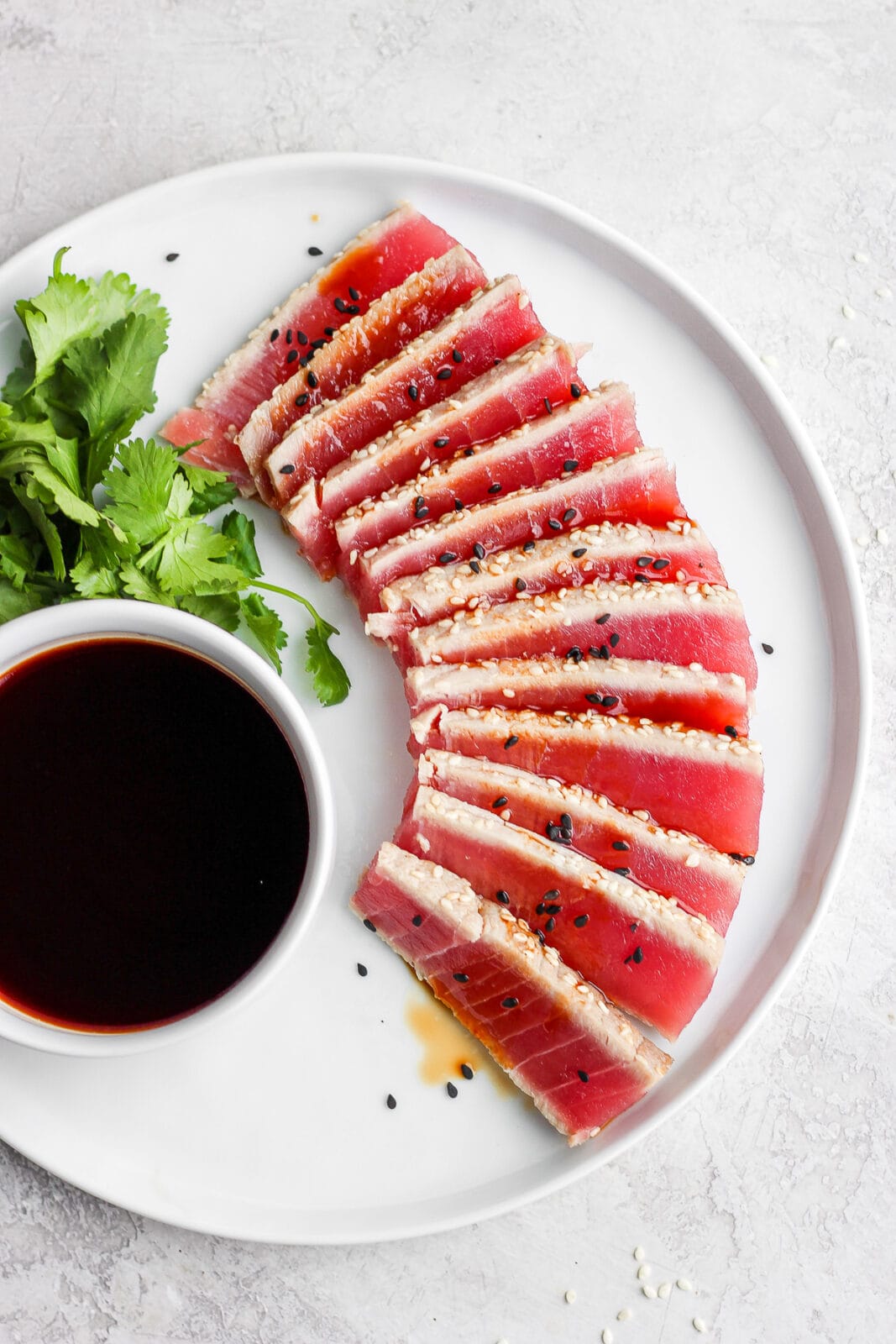 Plate of Simple Seared Ahi Tuna Recipe with soy sauce and cilantro on a plate. 