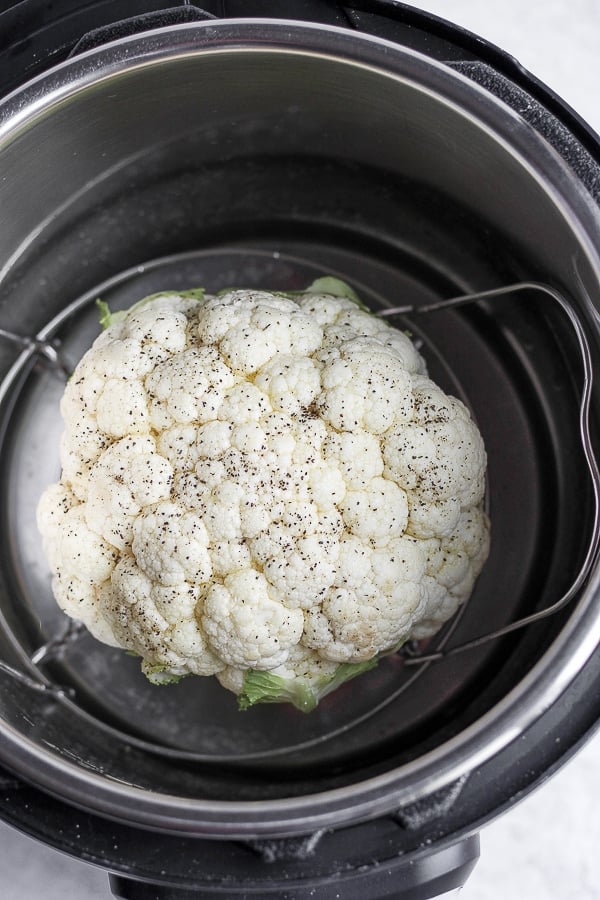 Head of cauliflower on the trivet in the Instant Pot.