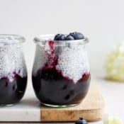 Two jars of coconut chia pudding with blueberries.