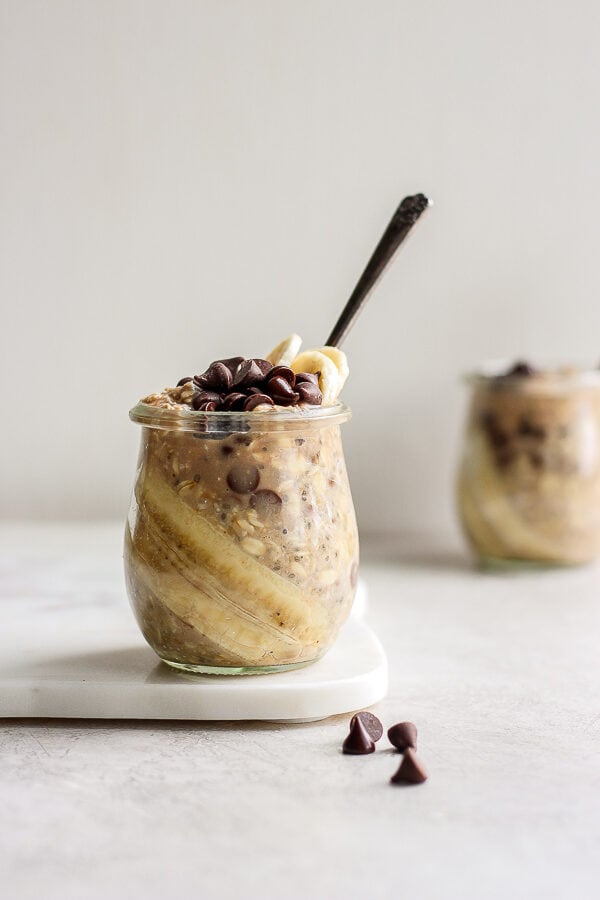 A jar of chocolate chip overnight oats with another jar in the background.
