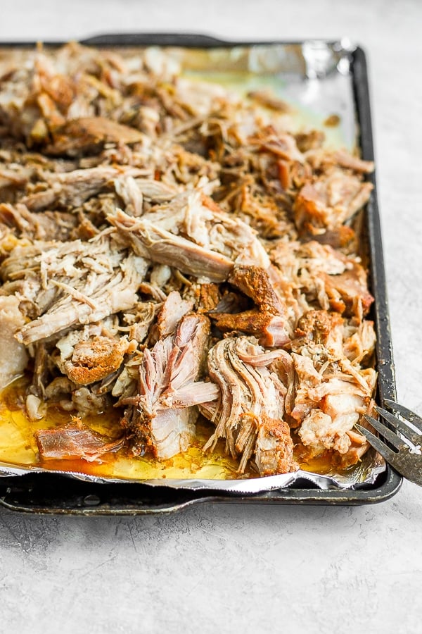 Foil-lined baking sheet with shredded sous vide pork shoulder on it. 