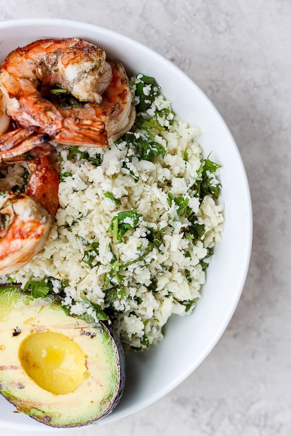 Cilantro Lime Cauliflower Rice in a bowl with avocado and shrimp. 