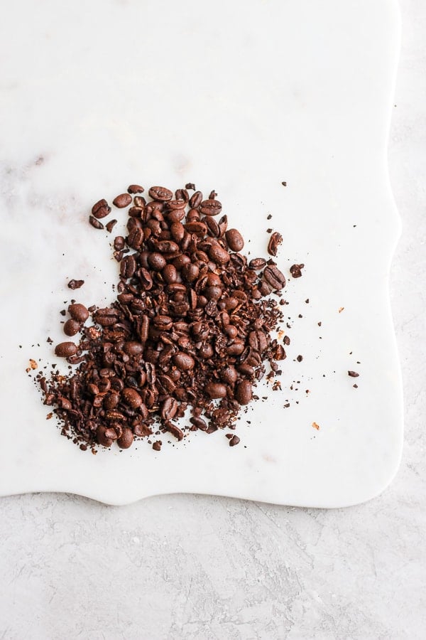 Roughly ground coffee beans on a marble board. 