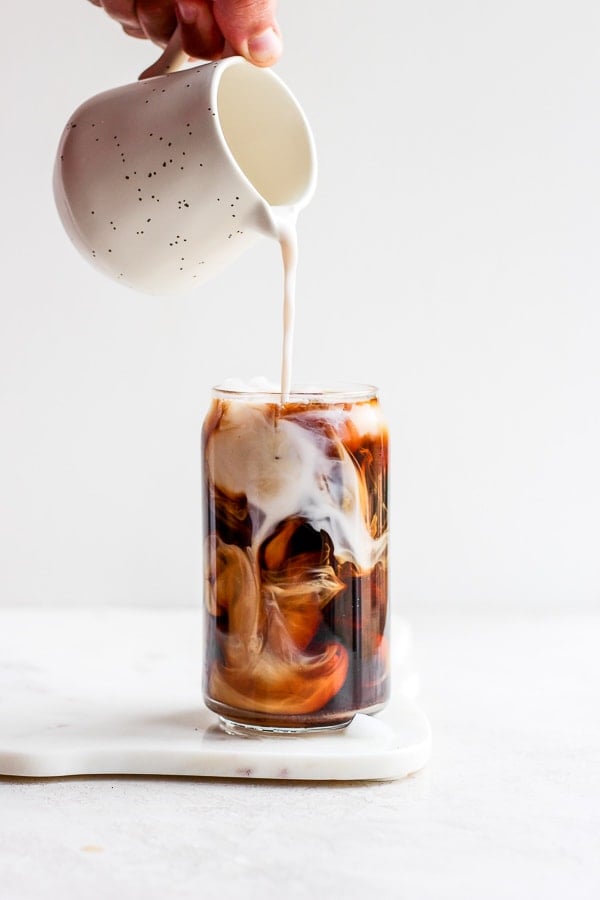 Cold brewed iced latte coffee on plastic cup, side view with