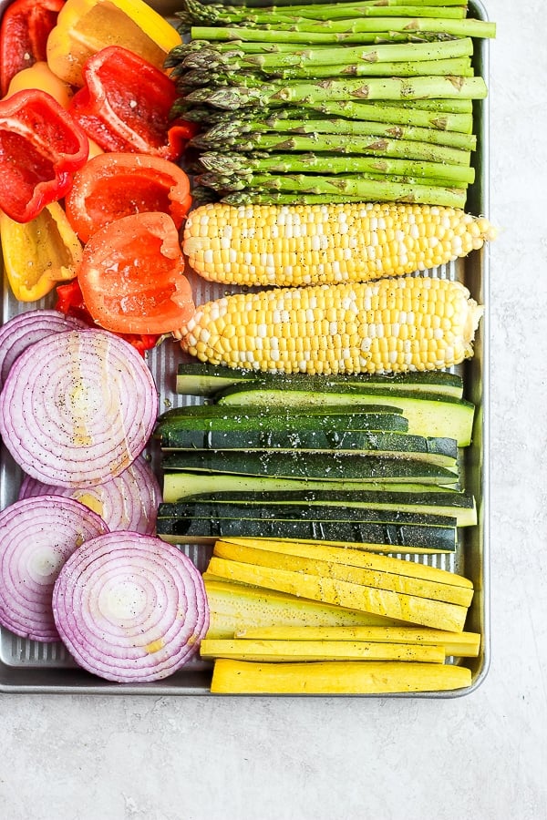 A sheet pan of vegetables drizzled in olive oil and sprinkled with salt and pepper. 