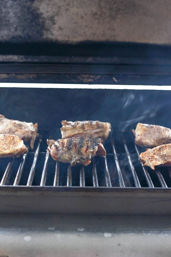 Bone-in and skin-in chicken thighs on the grill. 