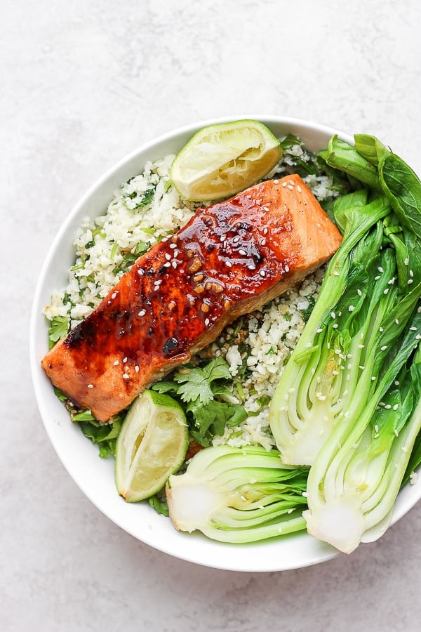 Ginger sesame salmon in a white bowl with sides.