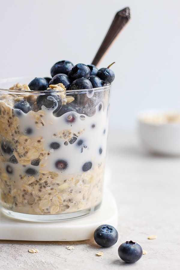 Glass filled with blueberry overnight oats. 
