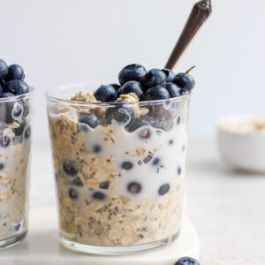 Blueberry overnight oats in glasses with a spoon in one glass.