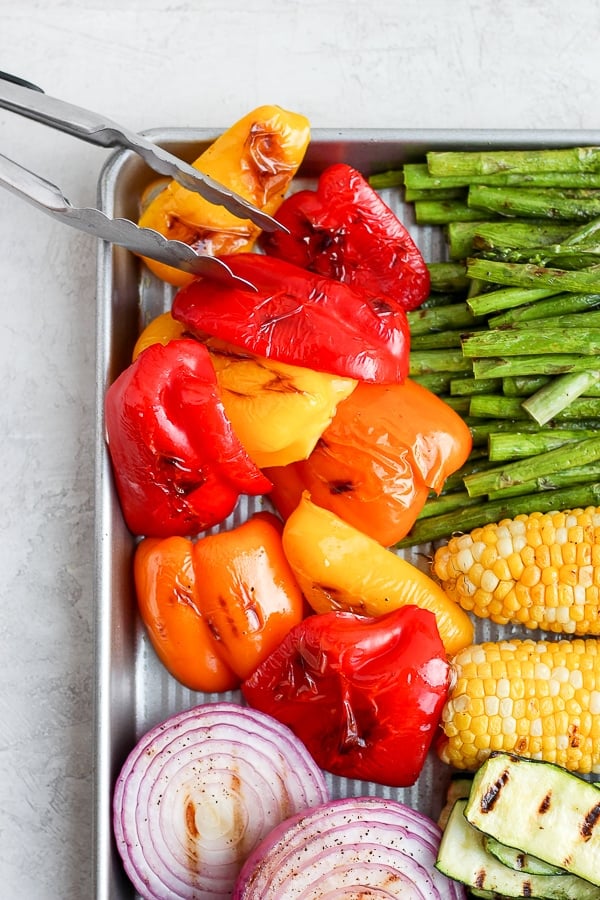 A sheet pan with grilled vegetables on it, including bell pepper. 