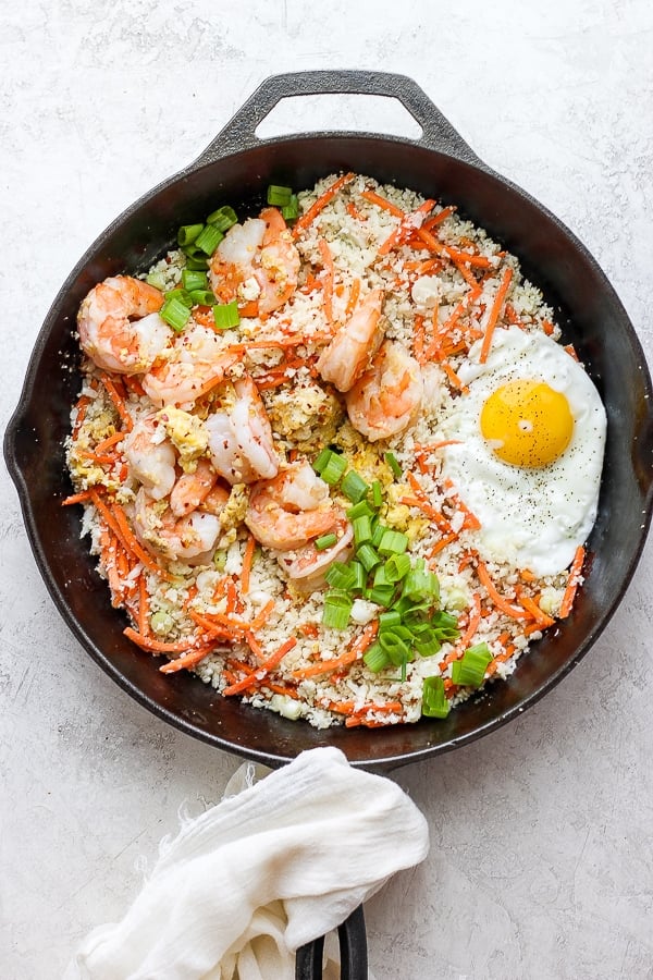 Shrimp fried cauliflower rice in a cast iron skillet. 