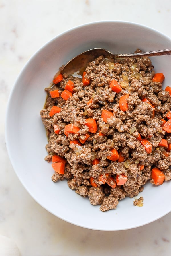 Ground beef mixture in a white bowl after being cooked.