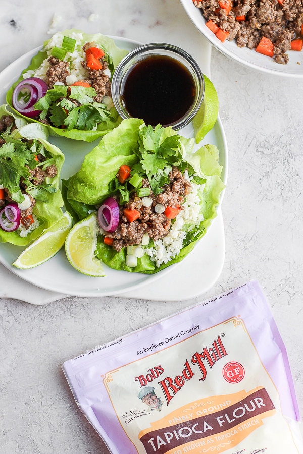 Lettuce wraps on a plate and a bag of Bob's Red Mill Tapioca Flour next to it.